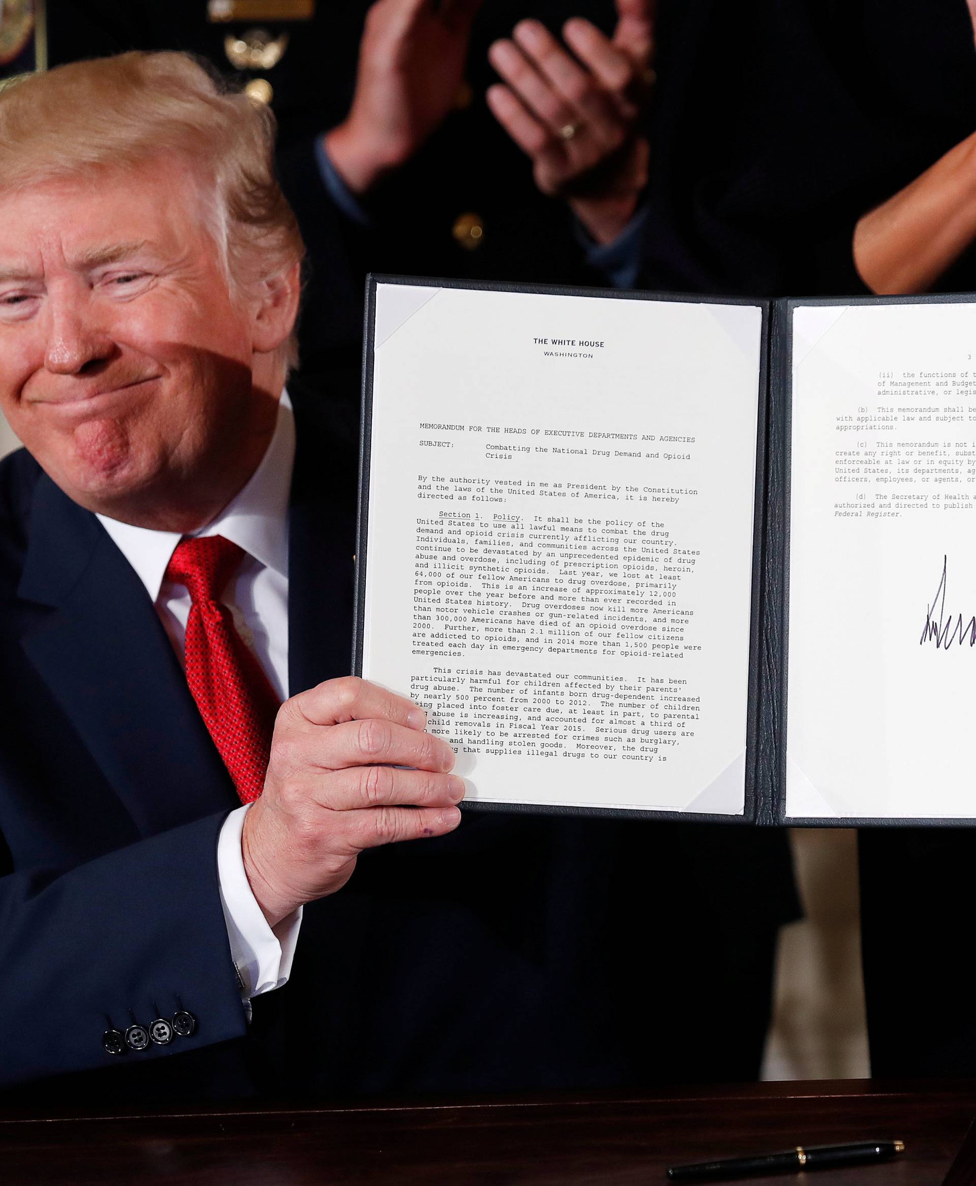 U.S. President Donald Trump displays a presidential public health emergency declaration on the nation's opioid crisis in the East Room of the White House in Washington