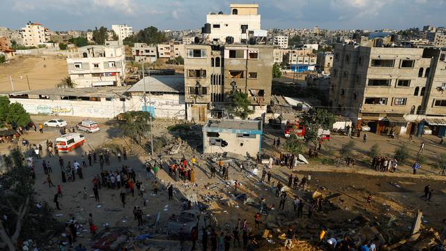 Palestinians gather at a site of Israeli strikes in Khan Younis