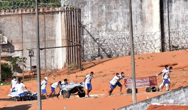 Inmates transport bodies after a prison riot in Natal