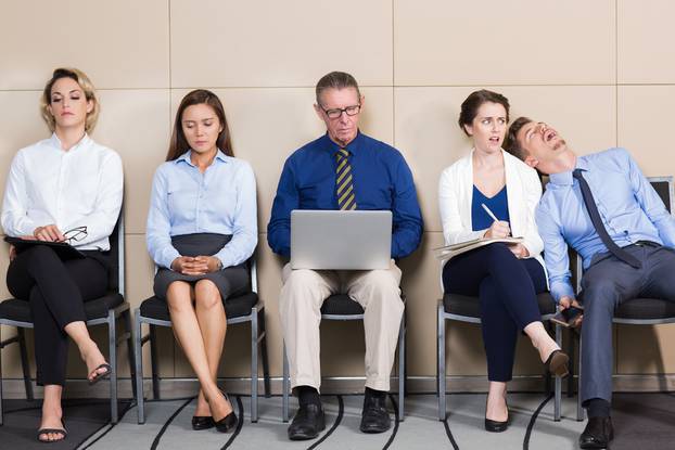 Five Bored Business People Sitting in Waiting Room