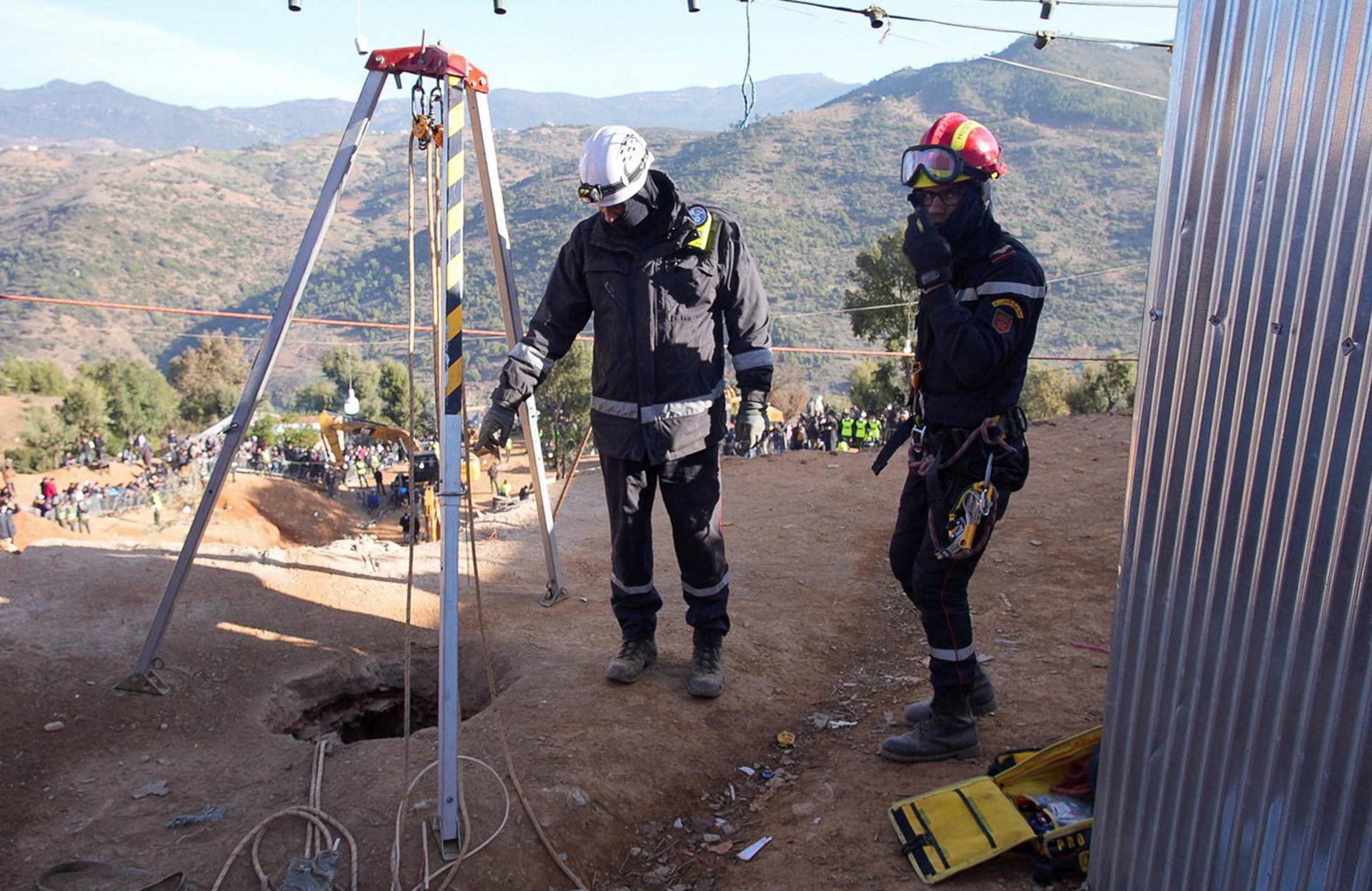 Rescuers stand near the hole of a well into which a five-year-old boy fell in the northern hill town of Chefchaouen
