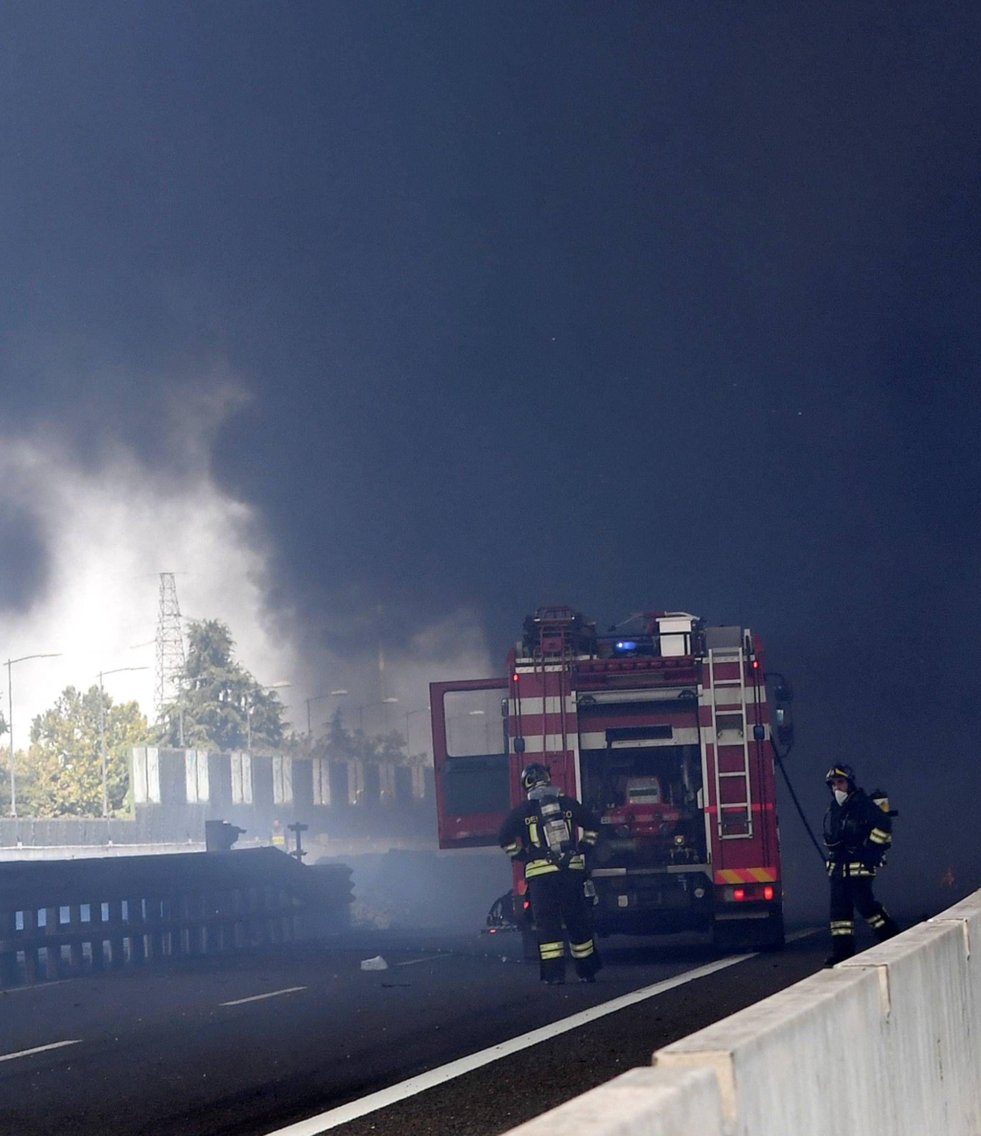 Firefighters work on the motorway after an accident caused a large explosion and fire at Borgo Panigale, on the outskirts of Bologna