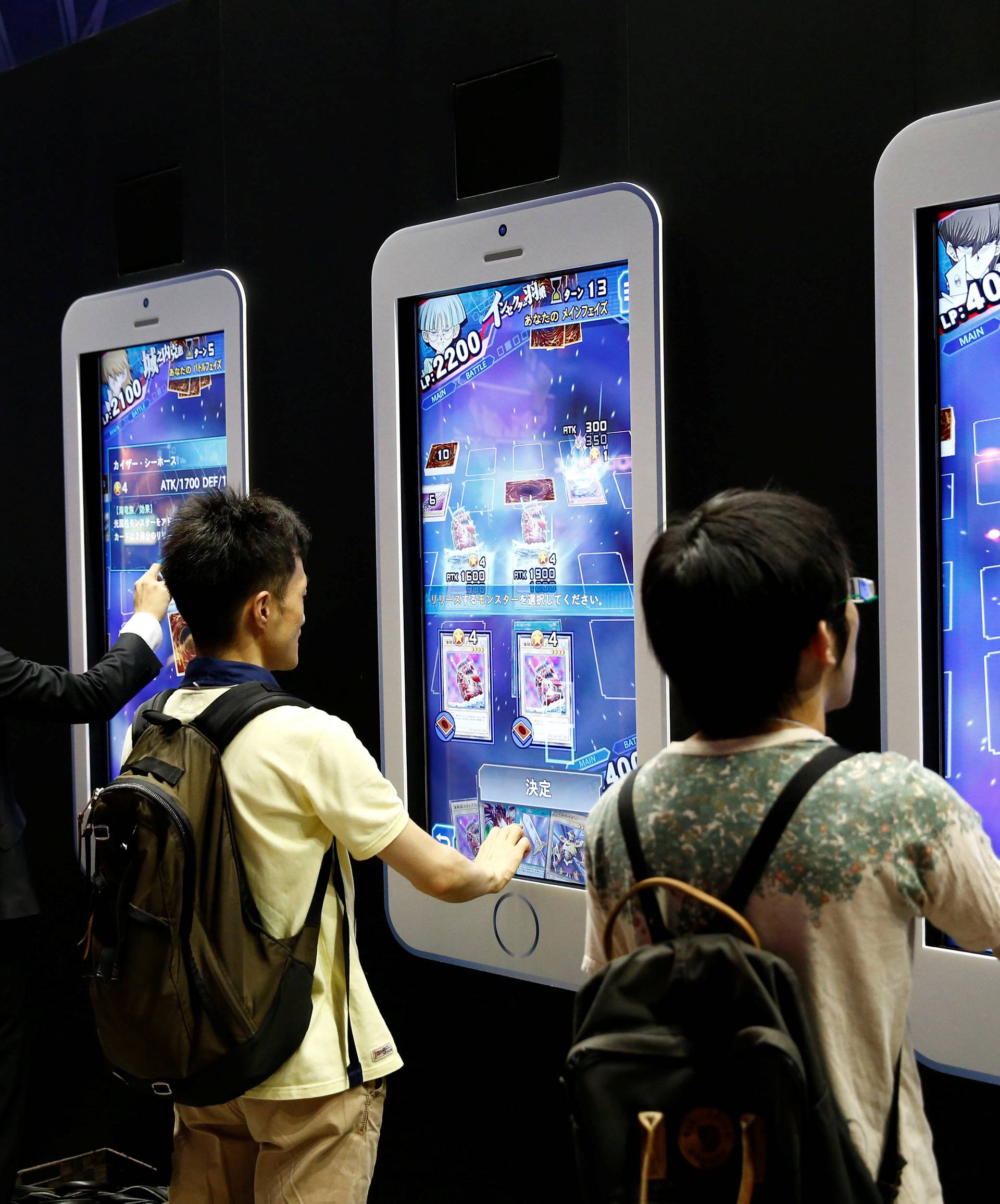 People play video games on mobile phone-shaped screens at Tokyo Game Show 2016 in Chiba