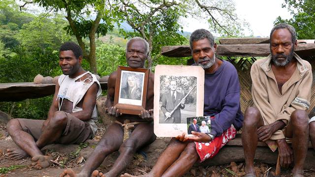 Chief Jack Malia from the Imanourane Tribe holds photographs of Britain's Prince Philip as he sits next to other villagers in the village of Younanen on Tanna Island in the Pacific island nation of Vanuatu