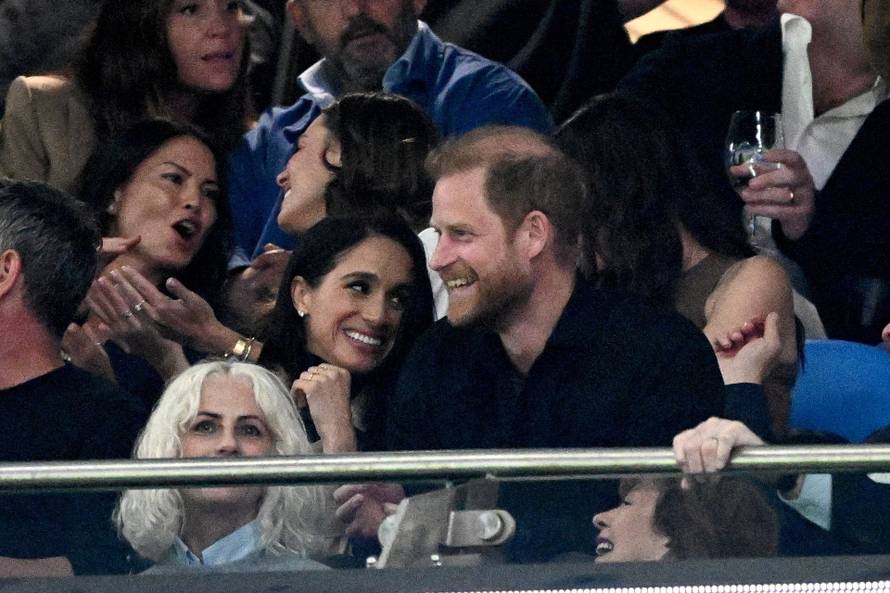 Britain's Prince Harry and Meghan react during the Super Rugby match between the NSW Waratahs and Moana Pasifika at Allianz Stadium, Sydney