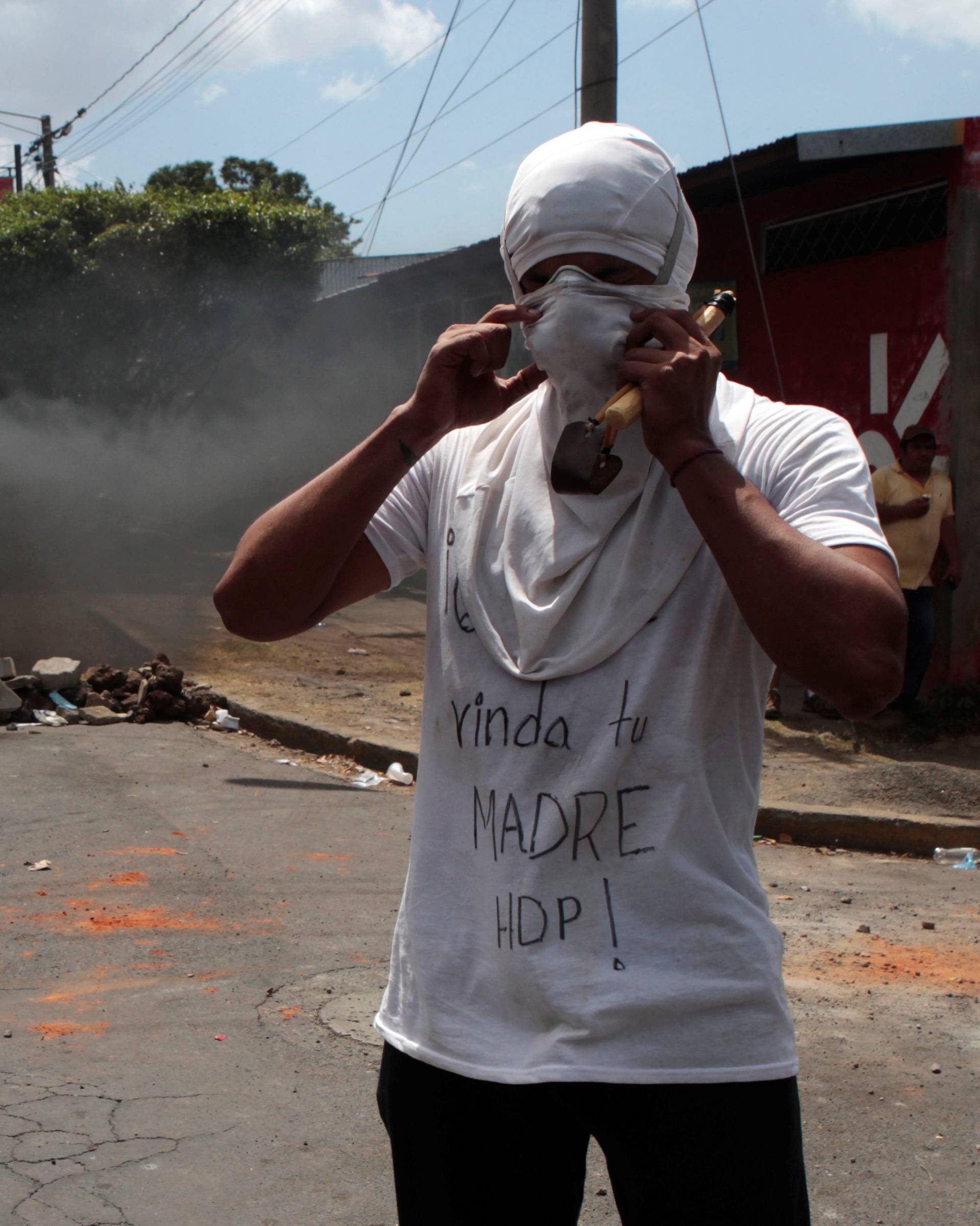 A demonstrator is seen next to a burning barricade during a protest over a controversial reform to the pension plans of the Nicaraguan Social Security Institute (INSS) in Managua