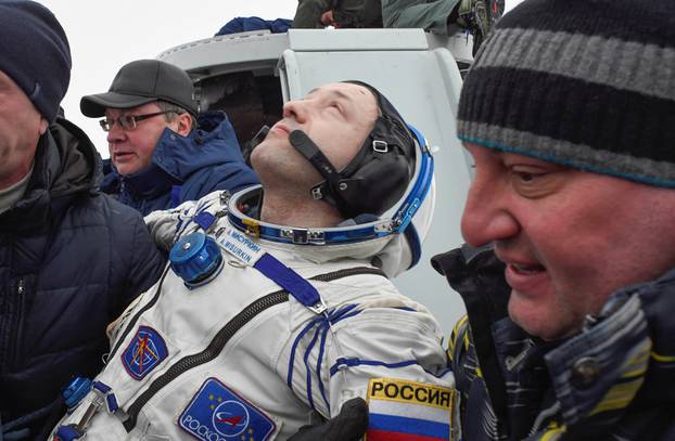Ground personnel carry Alexander Misurkin of Russia after the Soyuz MS-06 capsule landed in a remote area outside the town of Dzhezkazgan (Zhezkazgan), Kazakhstan