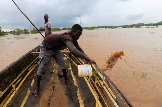 A man removes flood water from a boat as residents evacuate from their homes after River Nzoia burst its banks and due to the backflow from Lake Victoria, in Buyuku village of Budalangi