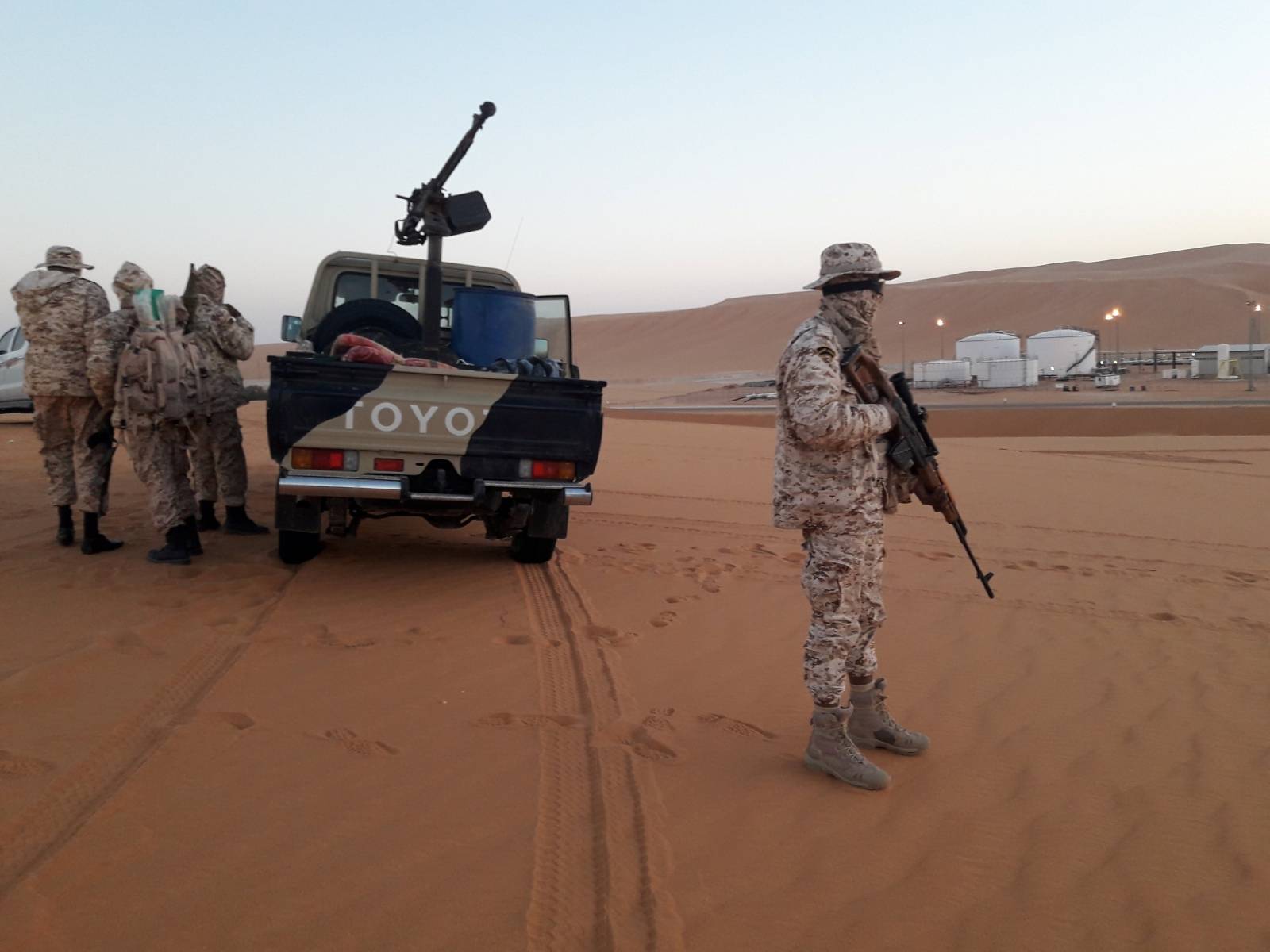 Members of forces loyal to Libyan military commander Khalifa Haftar guard near Libya's El Sharara oilfield  in Obari
