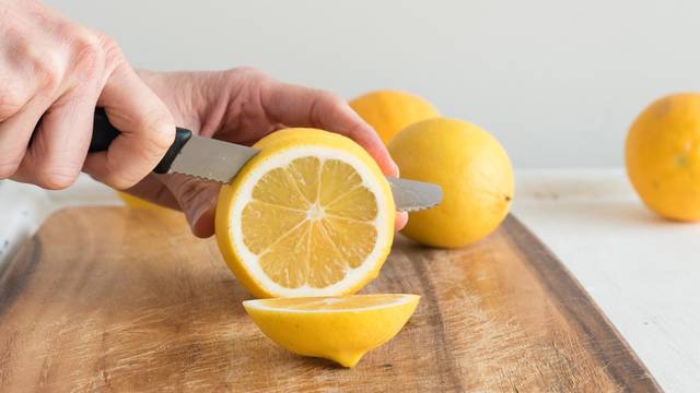 Middle aged woman's hands cutting lemons