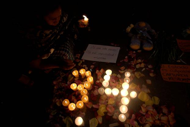 People light candles during a vigil for victims of a fire at the Virgen de Asuncion home in San Jose Pinula, outside National Palace in Guatemala City