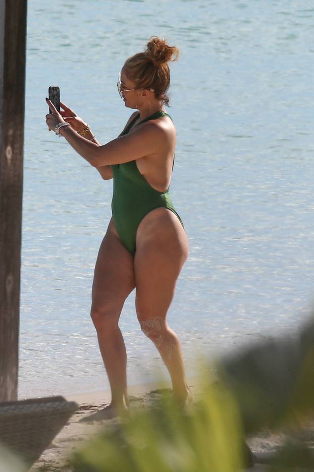 *PREMIUM-EXCLUSIVE* Jennifer Lopez is pictured in plunging green swimsuit as she soaks in the sun in Turks and Caicos **Web Embargo until 1 pm PST on January 15, 2021**