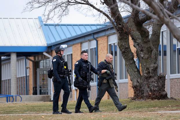 Law enforcement officers work at the scene of a shooting at Perry High School in Perry