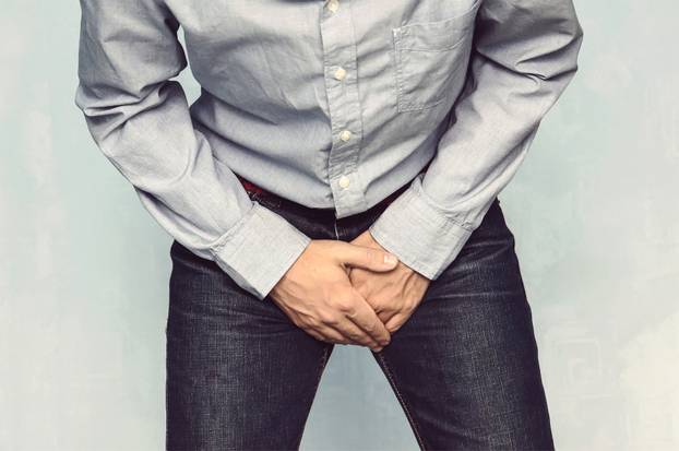 Man wants to pee and is holding his bladder.