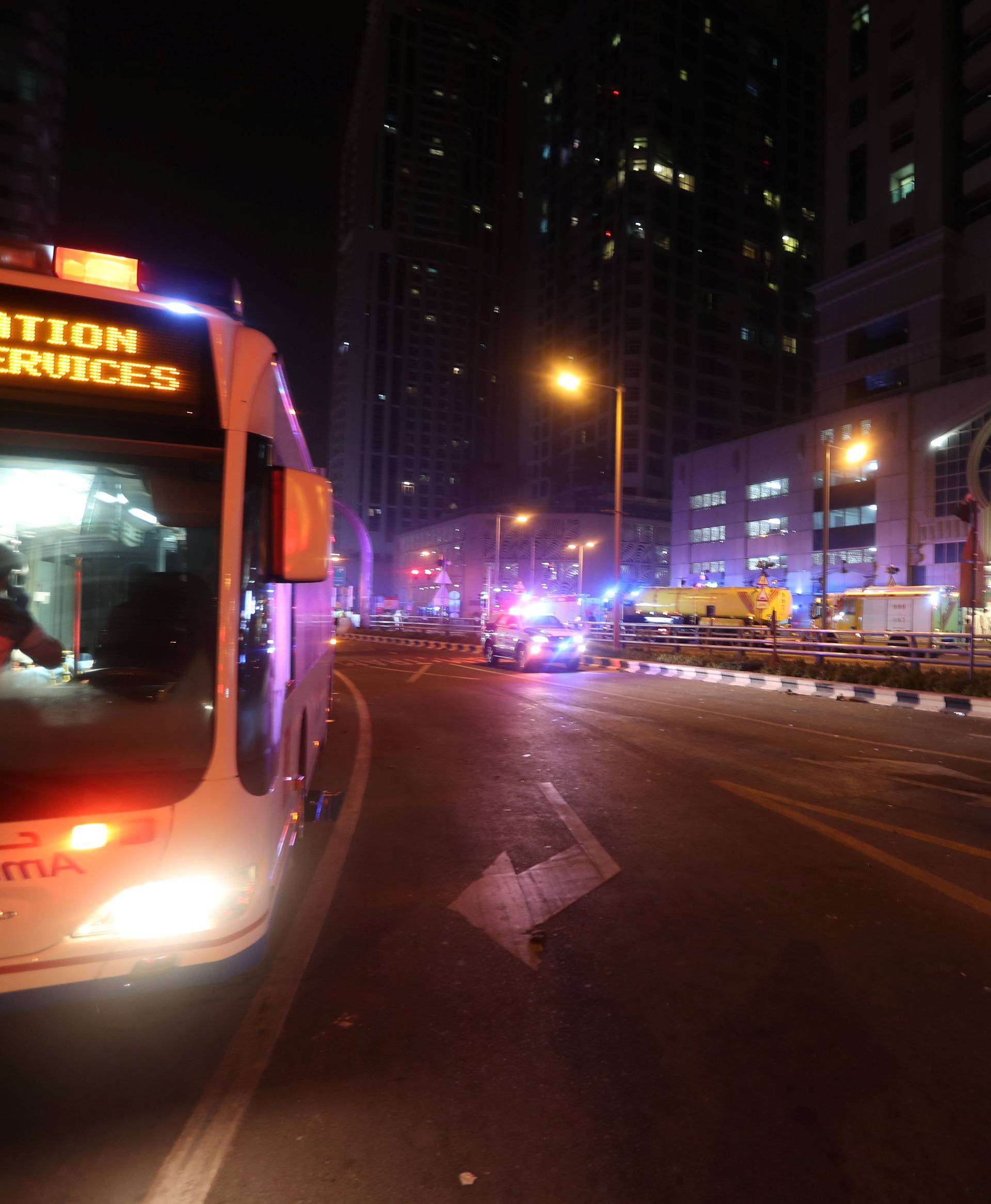 Dubai Emergency Response teams and Dubai police are seen on the street near Dubai's Torch tower residential building in the Marina district, Dubai