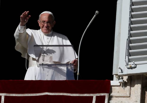Pope Francis waves during his Sunday Angelus prayer, on the day of his birthday, in Saint Peter