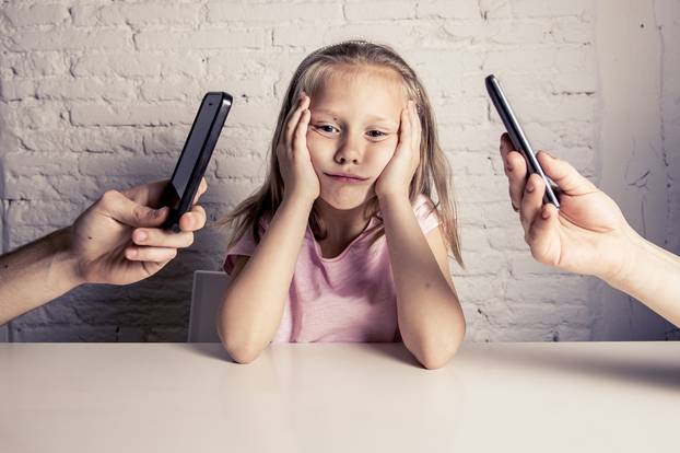 hands of network addict parents using mobile phone neglecting little sad ignored daughter bored