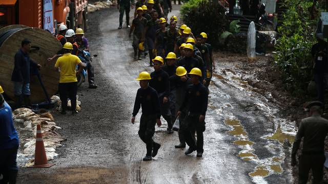 Military personnel walk in line as they prepare to enter the Tham Luang cave complex, where 12 boys and their soccer coach are trapped, in the northern province of Chiang Rai