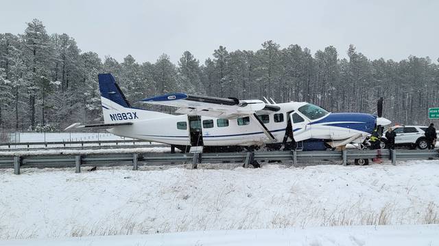 An small plane stands on a highway near the Washington Dulles International Airport following an emergency landing, in Virginia