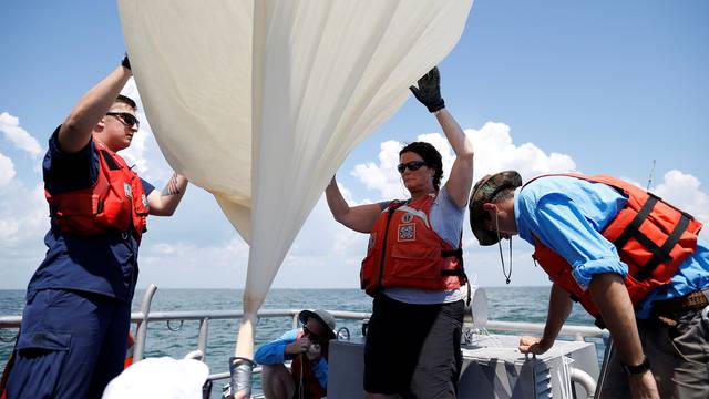 Students and faculty with the College of Charleston and the US Coast Guard, prepare to launch a test balloon for the Space Grant Ballooning Project, in preparations for Monday's solar eclipse on board a US Coast Guard response boat at sea near Charleston