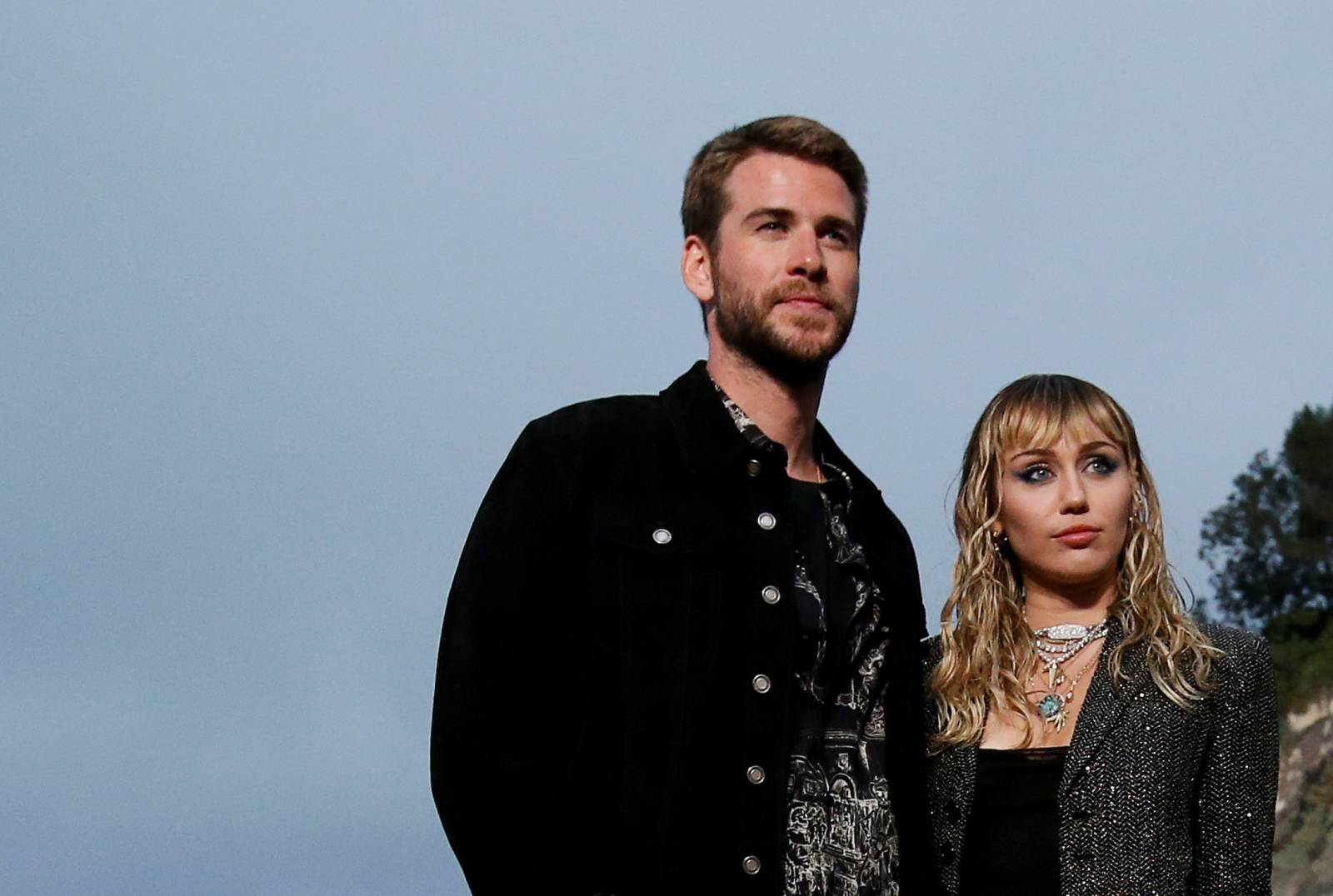 Miley Cyrus and Liam Hemsworth look on at the Saint Laurent Menâs Spring/Summer 2020 fashion show at Paradise Cove beach in Malibu