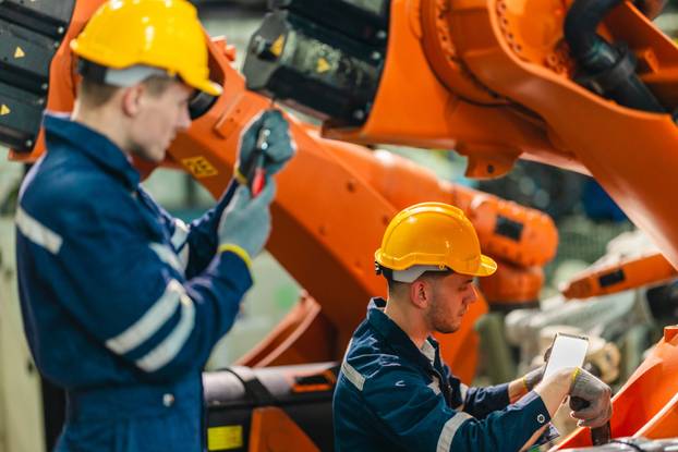 Technician Servicing Industrial Robot Arm