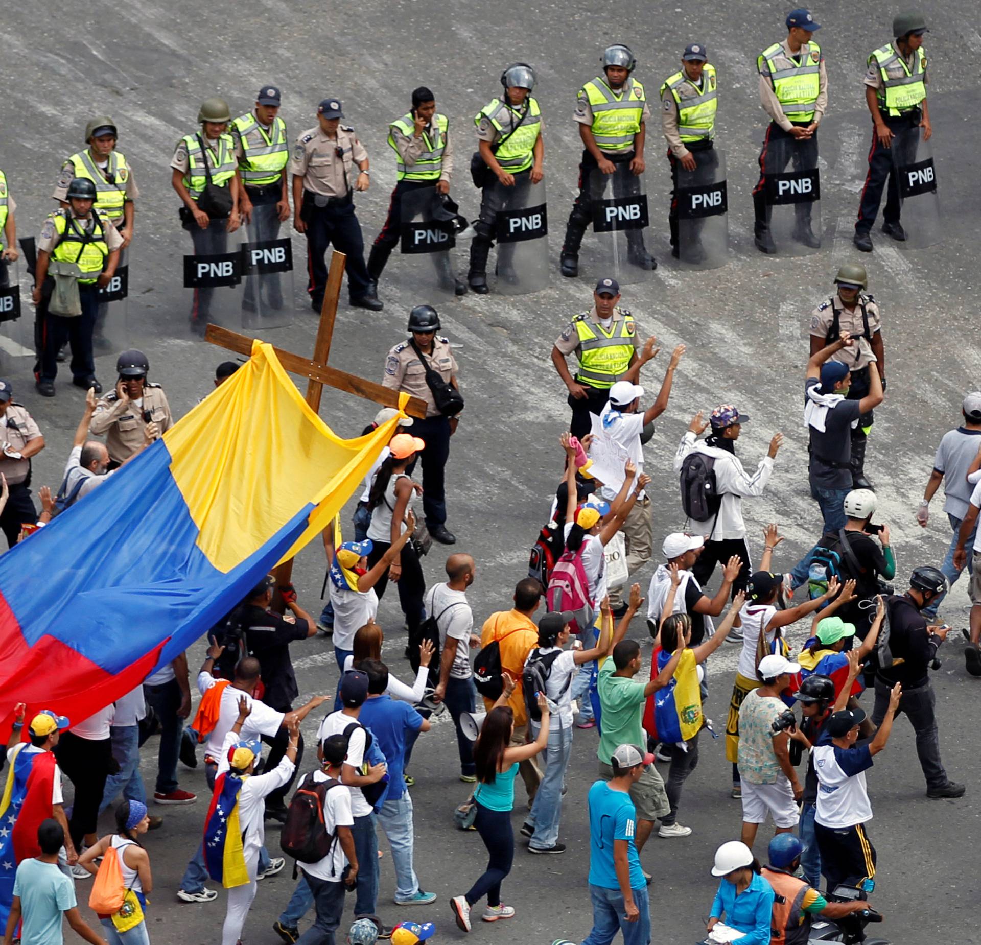 Demonstrators hold a cross as they take part in a rally to honour victims of violence during a protest against Venezuela's President Nicolas Maduro's government in Caracas
