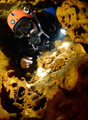 A scuba diver looks at an animal skull at Sac Aktun underwater cave system during exploration as part of the Gran Acuifero Maya Project near Tulum