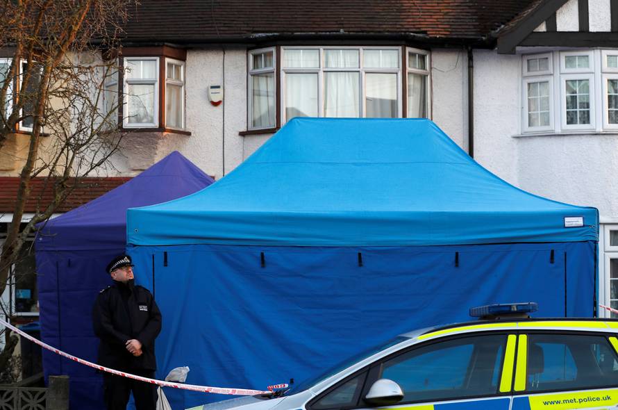 A police officer stands guard outside the home of Nikolai Glushkov in New Malden