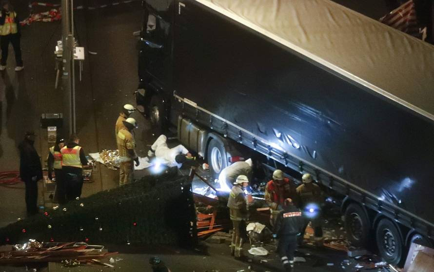Rescuers and police investigators inspect a truck that ploughed through crowd of a Berlin Christmas market