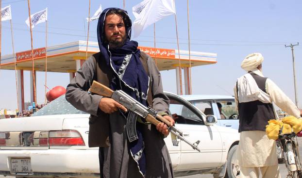 A Taliban fighter looks on as he stands at the city of Ghazni