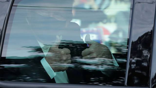 FILE PHOTO: U.S. President Donald Trump gestures from a car as he rides in front of  the Walter Reed National Military Medical Center, where he is being treated for the coronavirus disease (COVID-19) in Bethesda, Maryland