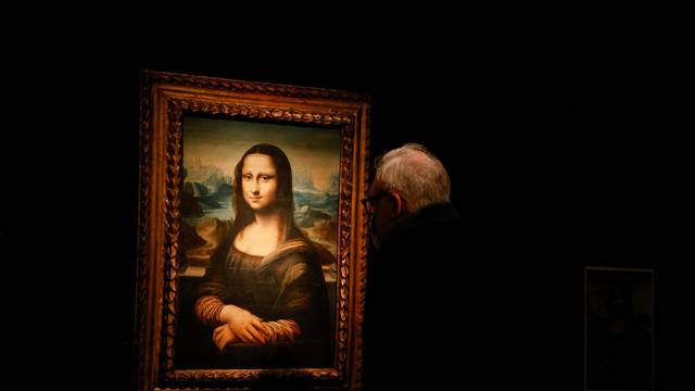A visitor looks at a copy of the Leonardo da Vinci's Mona Lisa, which will go up for auction on November 9, at the Artcurial auction house in Paris