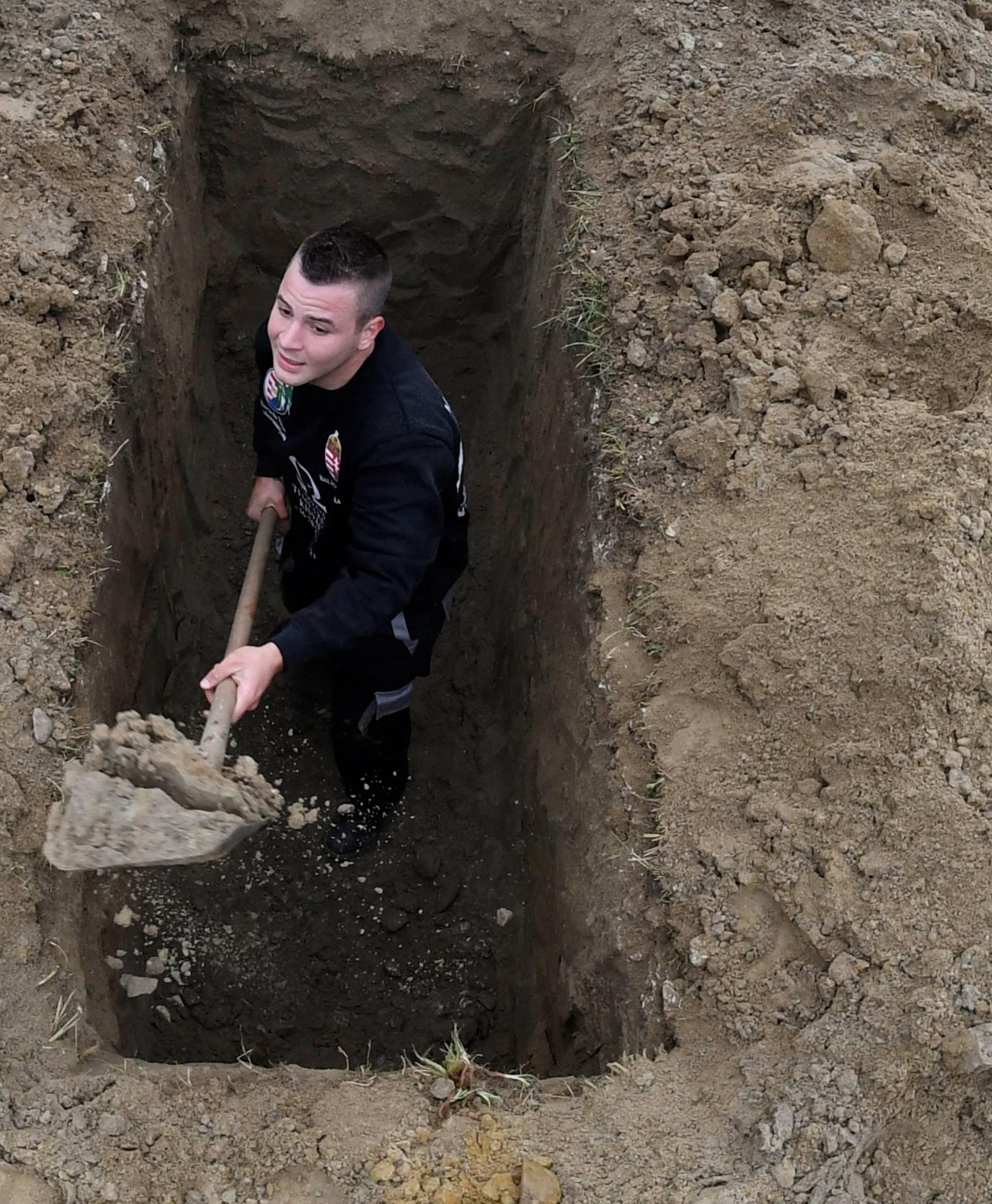 A gravedigger competes during a grave digging championship in Trencin, Slovakia