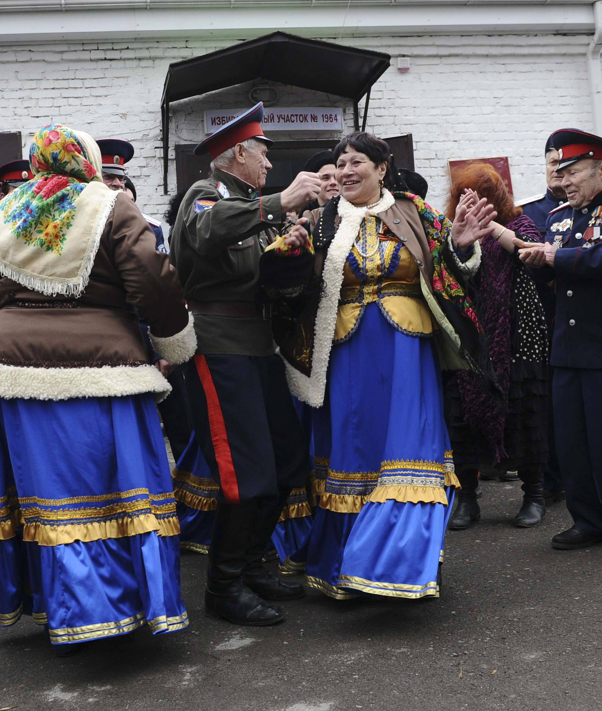 Members of a local Cossack community dance outside a polling station during the presidential election in Rostov-on-Don