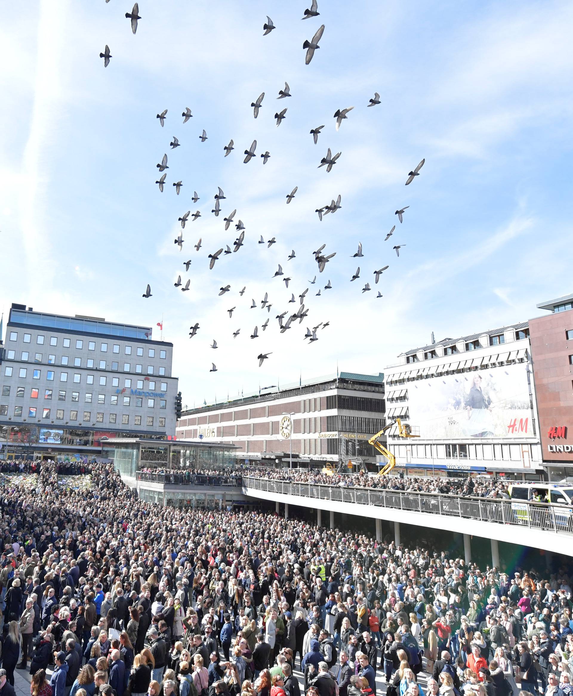 People gather in Sergels torg in central Stockholm for a "Lovefest" vigil against terrorism following Friday's attack