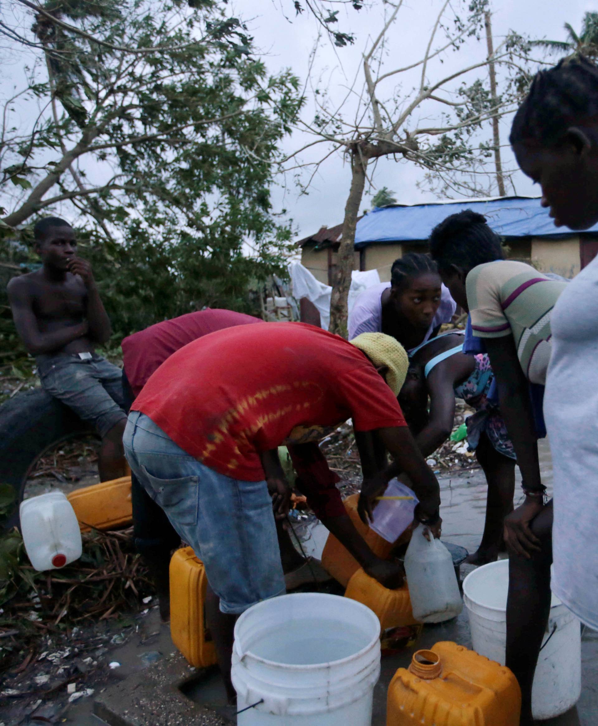 Residents collect water after Hurricane Matthew in Les Cayes