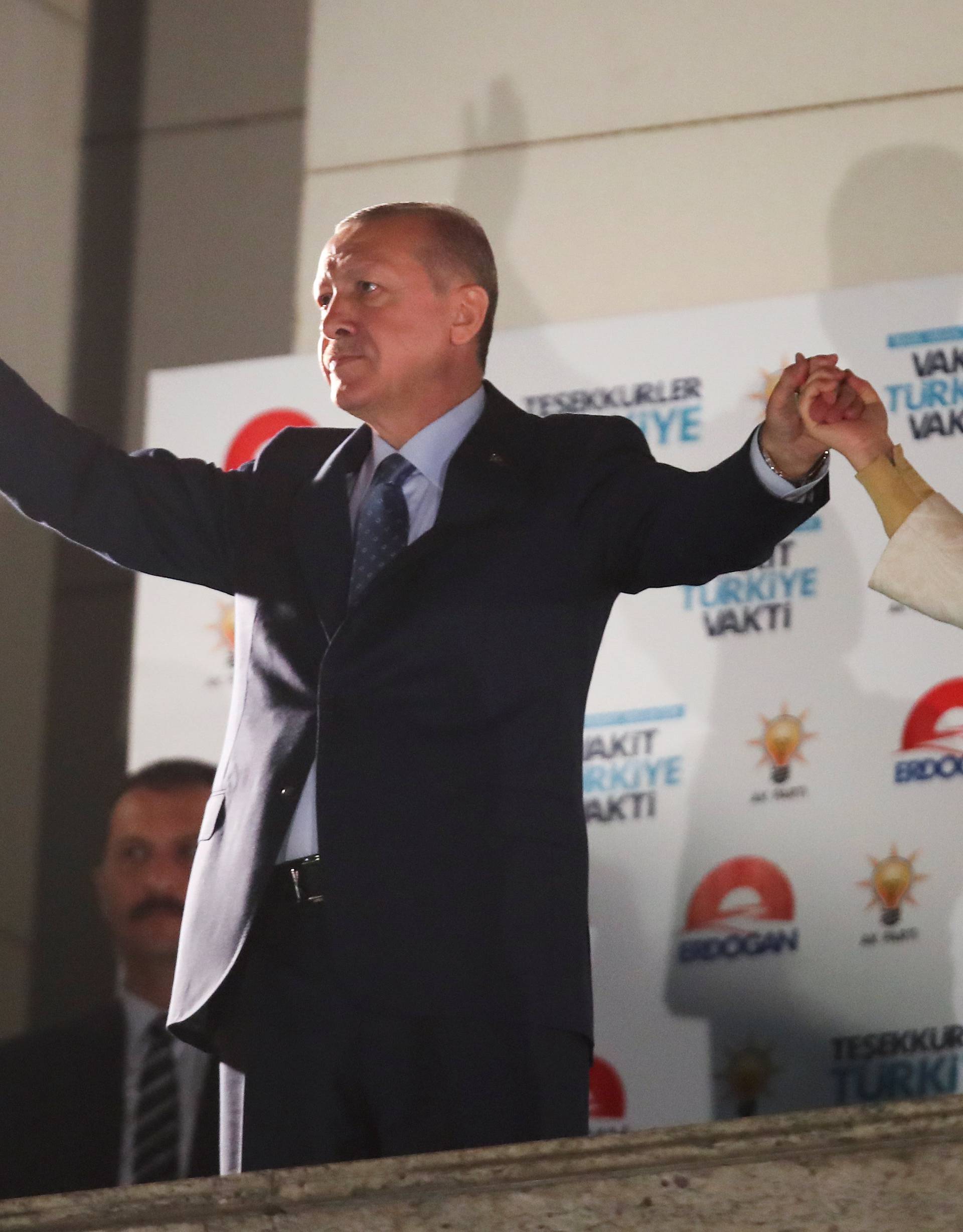 Turkish President Tayyip Erdogan and his wife Emine Erdogan greet supporters at the AKP headquarters in Ankara