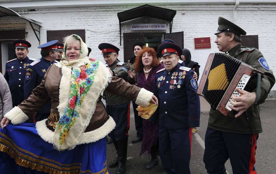 Members of a local Cossack community dance outside a polling station during the presidential election in Rostov-on-Don