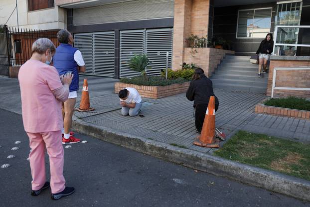 People gather outside a building following an earthquake in Bogota