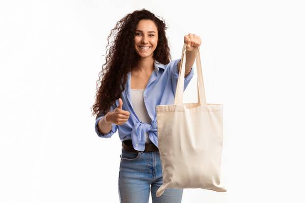 Cheerful Lady Showing Cotton Shopper Bag Gesturing Thumbs-Up, White Background