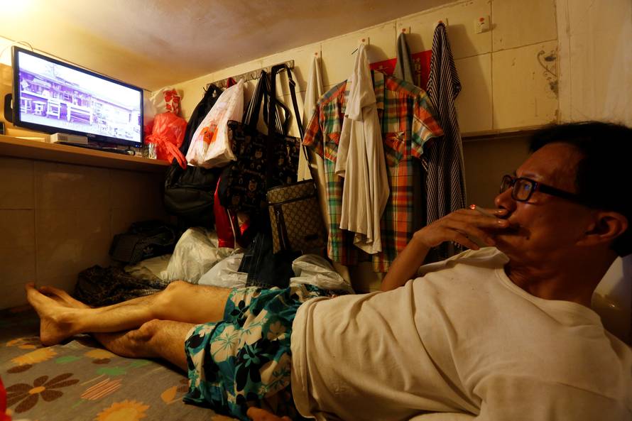 Unemployed Hong Kong resident Simon Wong, 61, watches TV inside his 4-by-6-feet partitioned unit, or "coffin unit", with a monthly rent of HK$1,750 ($226) in Hong Kong