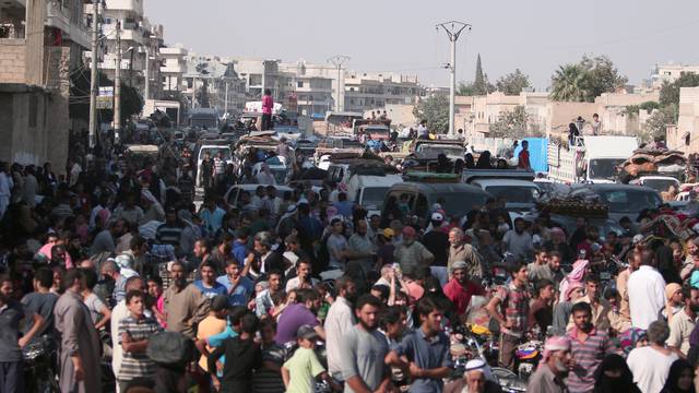 Civilians gather after they were evacuated by the Syria Democratic Forces (SDF) fighters from an Islamic State-controlled neighbourhood of Manbij