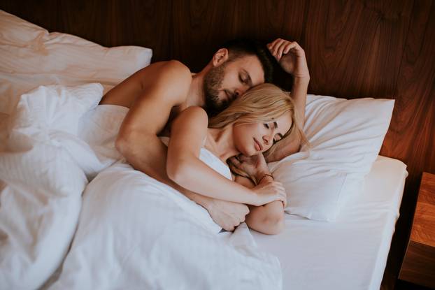 Lovely couple hugging on their bed at home