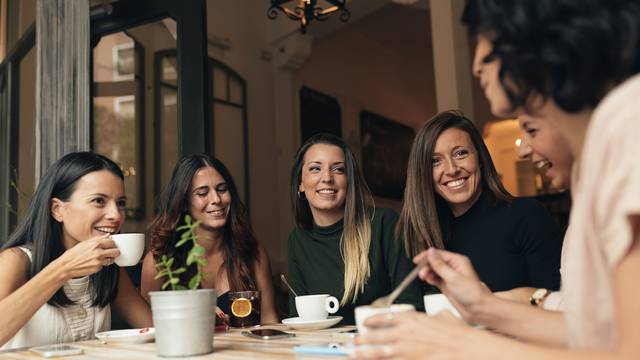 Six beautiful women drinking coffee and chatting.