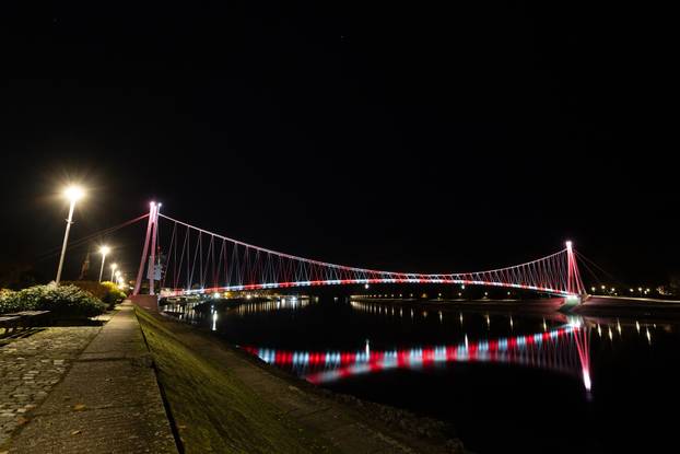 Osijek: Pješački most osvijetljen crveno bijelom  bojom povodom Dana sjećanja na žrtvu Vukovara i Škabrnje