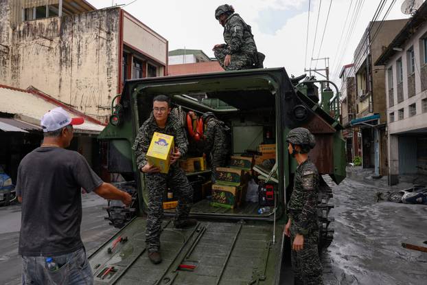 Soldiers distribute supplies from an armored vehicle after Super Typhoon Ragasa in Hualien