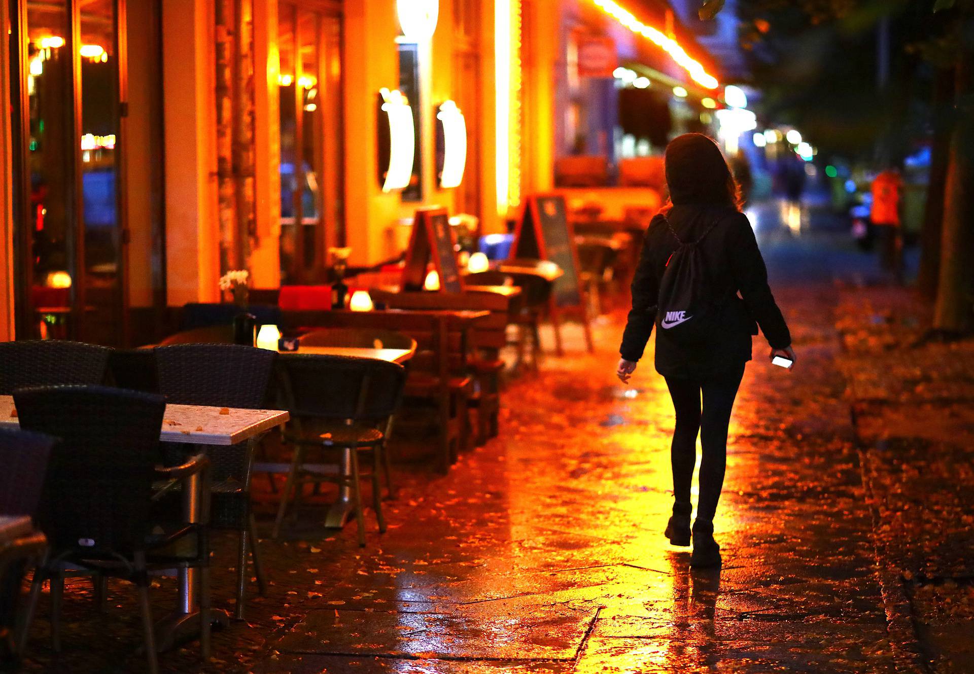 A woman passes empty tables before the late-night curfew due to restrictions against the spread of the coronavirus disease (COVID-19)in Berlin