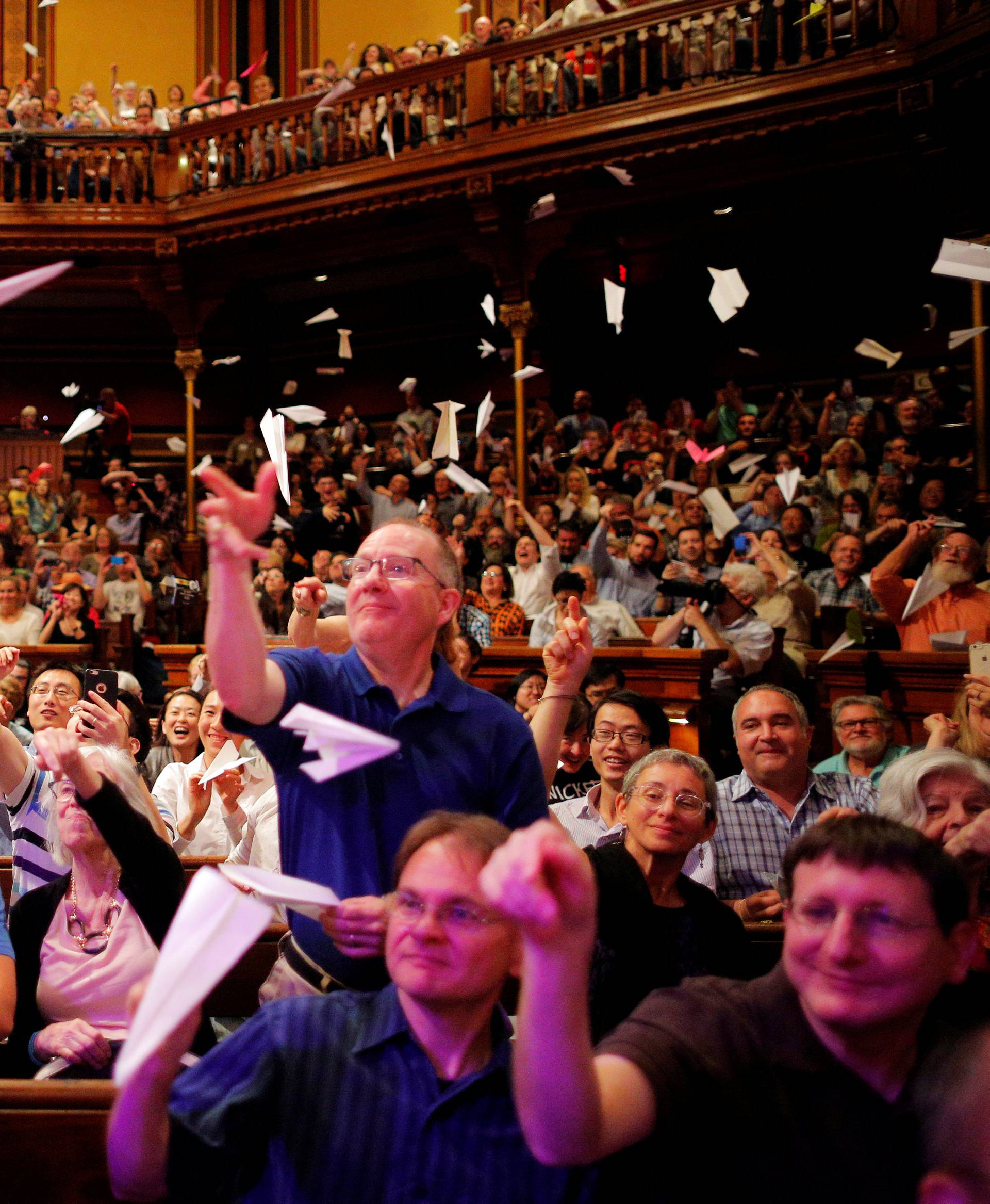 Audience members throw paper airplanes at the stage during the 26th First Annual Ig Nobel Prize ceremony at Harvard University in Cambridge