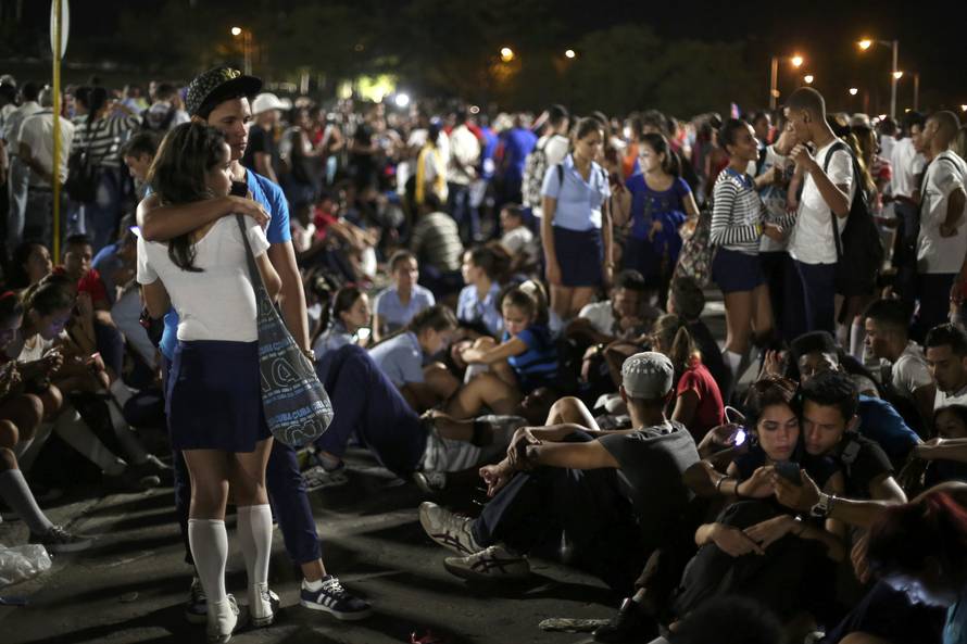 Mourners embrace while attending a tribute to Cuba's late President Fidel Castro at Revolution Square in Havana